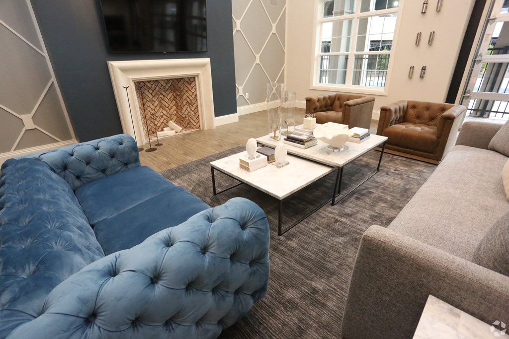 a living room with couches and chairs and a fireplace at Century Baxter Avenue, Louisville, 40204