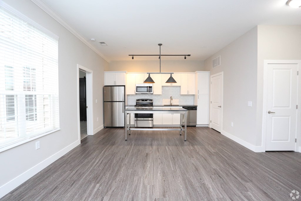 a spacious living room with a kitchen and a large window at Century Baxter Avenue, Louisville, KY