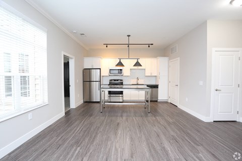 a spacious living room with a kitchen and a large window at Century Baxter Avenue, Louisville, KY