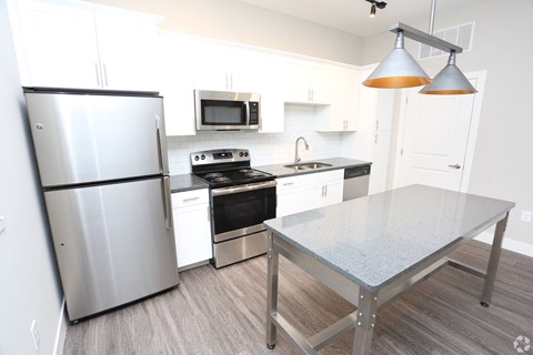 a kitchen with stainless steel appliances and a table at Century Baxter Avenue, Louisville, KY 40204