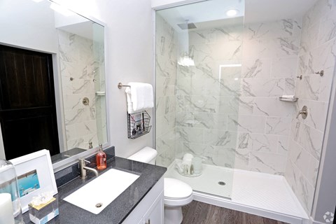 a bathroom with a shower and a sink and a mirror at Century Baxter Avenue, Louisville, KY 40204