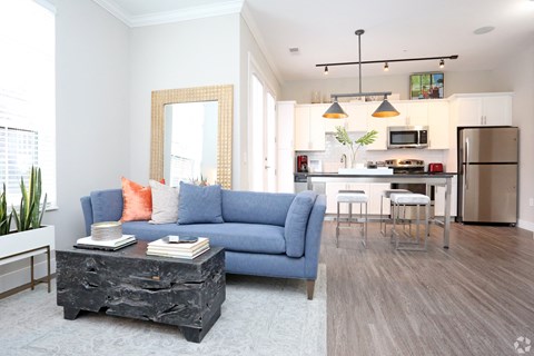 a living room and kitchen with a blue couch and a table at Century Baxter Avenue, Louisville