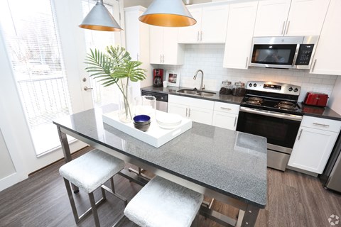 a kitchen with white cabinets and a gray counter top at Century Baxter Avenue, Louisville, 40204