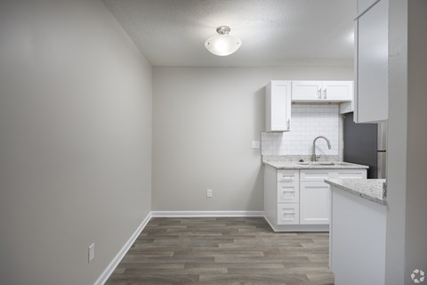 A kitchen with white cabinets and a countertop.