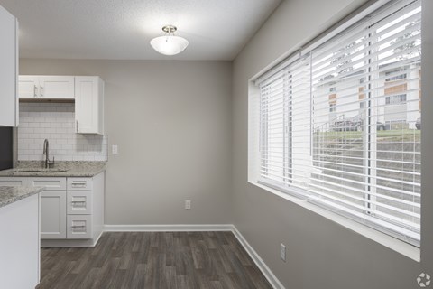 A kitchen with white cabinets and a granite countertop.