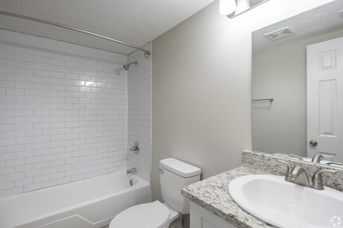 A white bathroom with a toilet, sink, and bathtub.