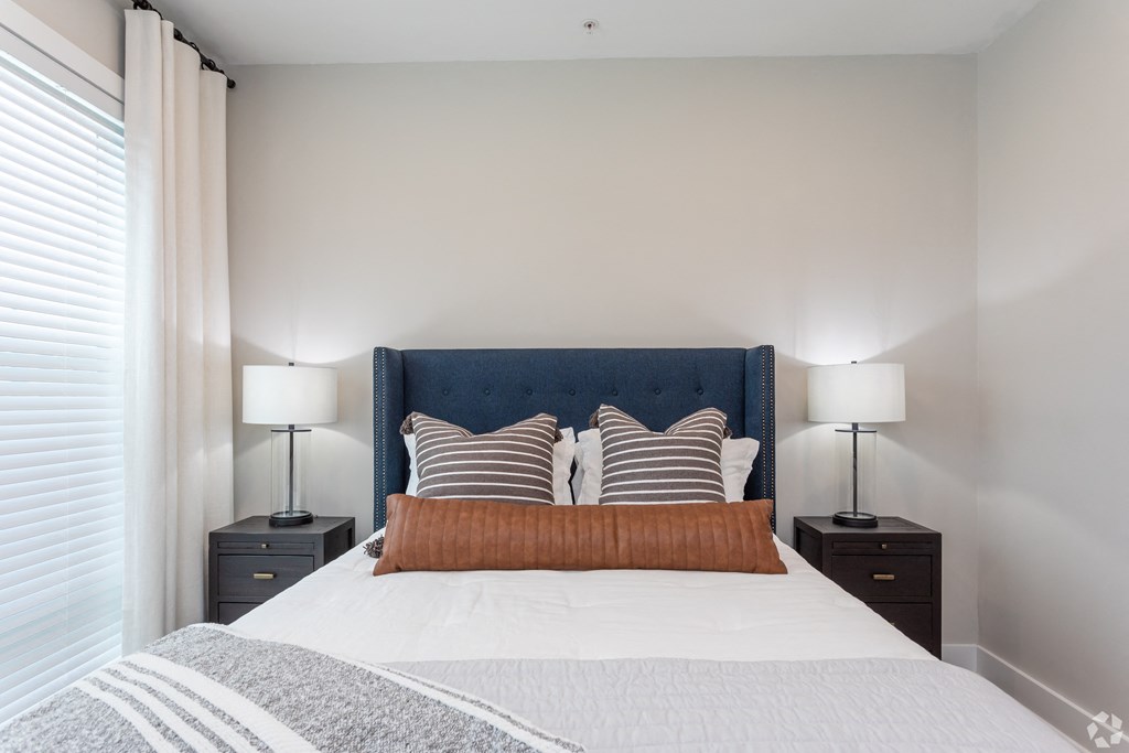 a bedroom with a large bed with pillows and a window