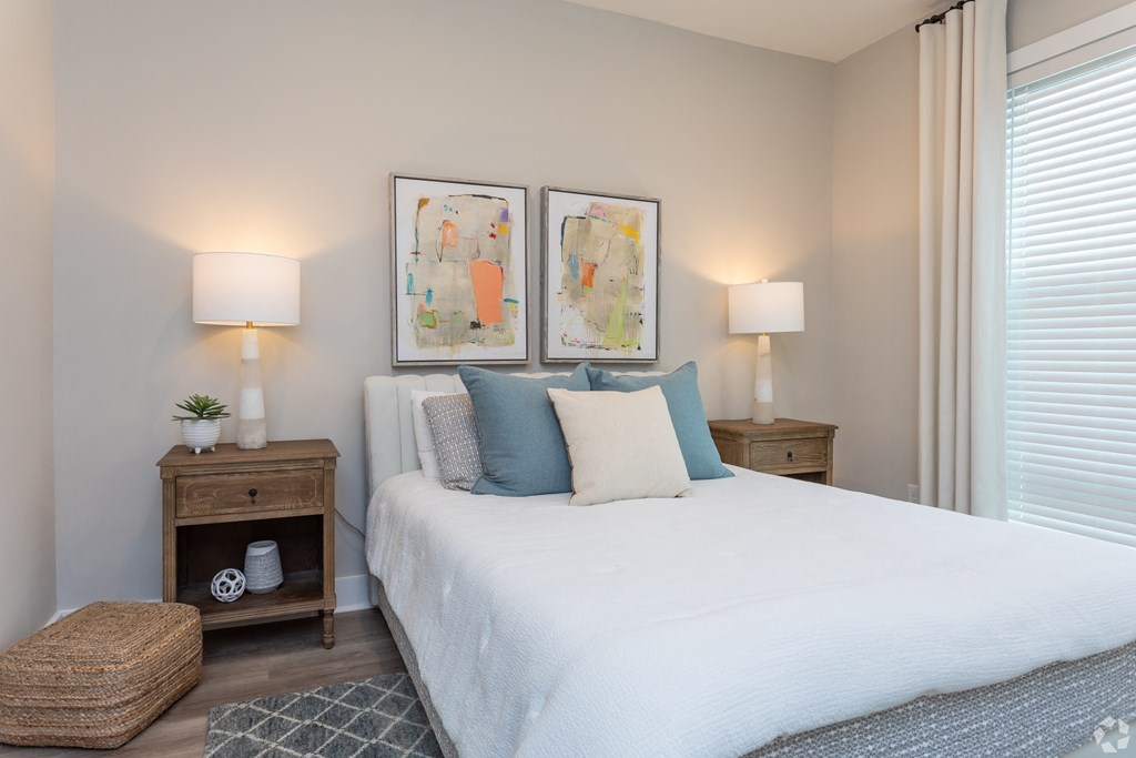 a bedroom with a white bed and two paintings on the wall