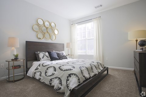 a bedroom with a bed and a dresser and a window