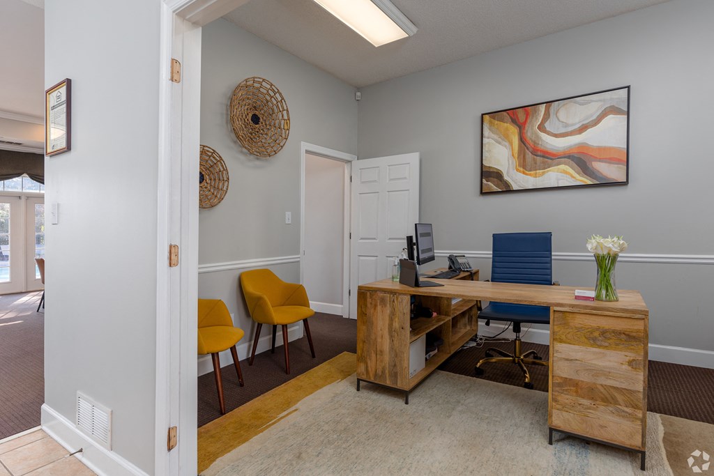 a home office with a wooden desk and yellow chairs