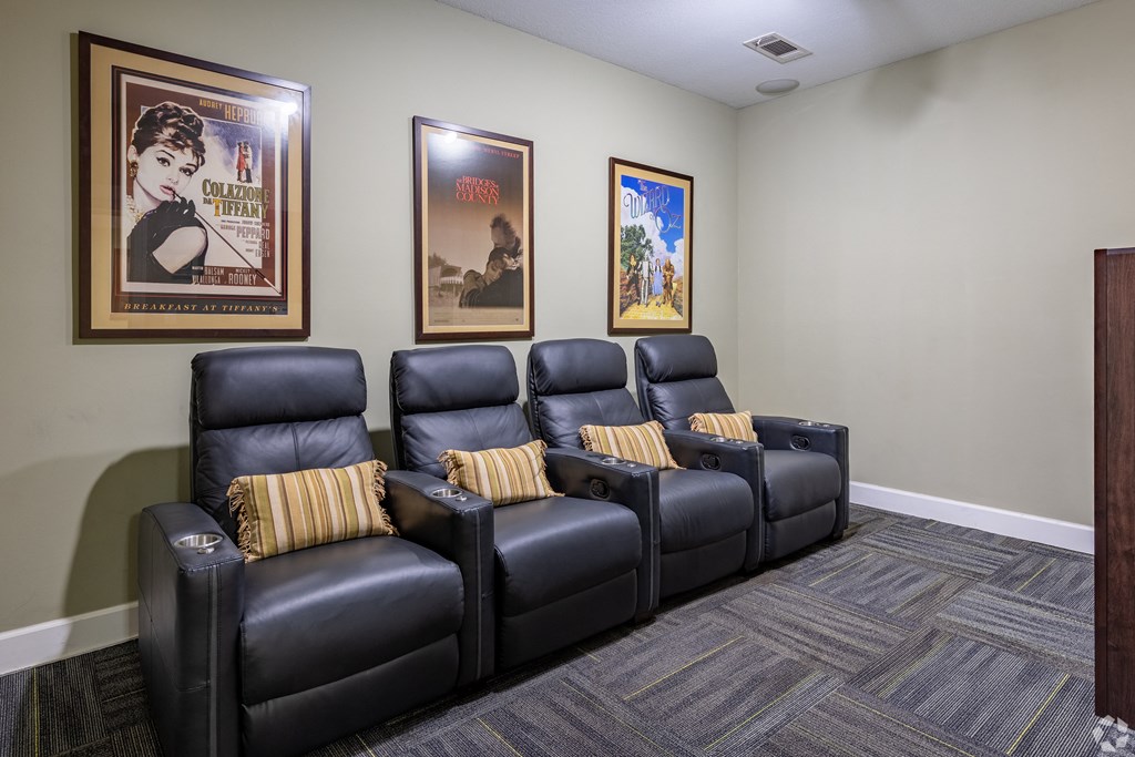 a room with black leather chairs with yellow pillows
