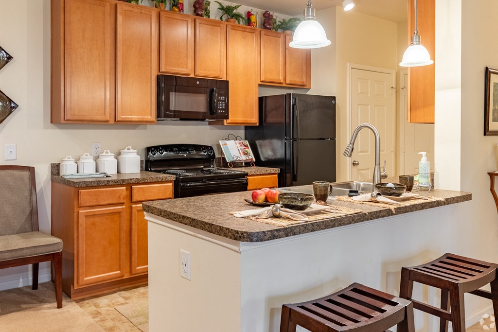 a kitchen with wood cabinets and black appliances
