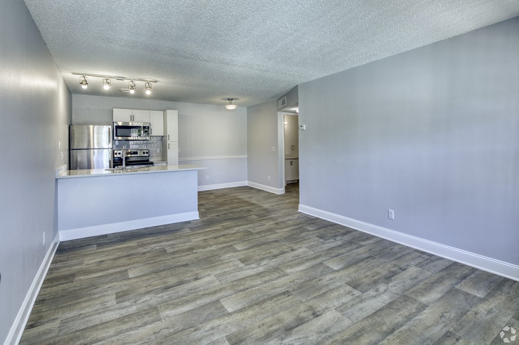 the living room and kitchen of an apartment with wood flooring at Beach Club, Florida