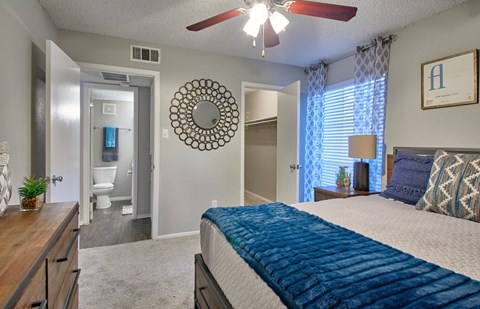A bedroom with a bed, dresser, and mirror.