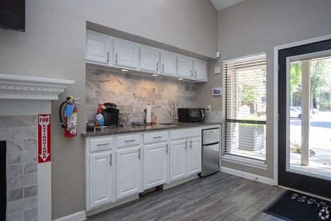 a kitchen with white cabinets and a sink and a window