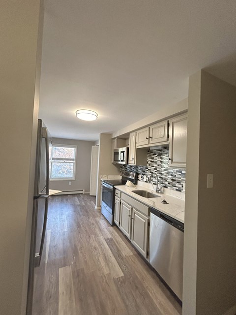 a kitchen with white cabinets and stainless steel appliances at Briarcliff at Quechee Apartments, Quechee, VT