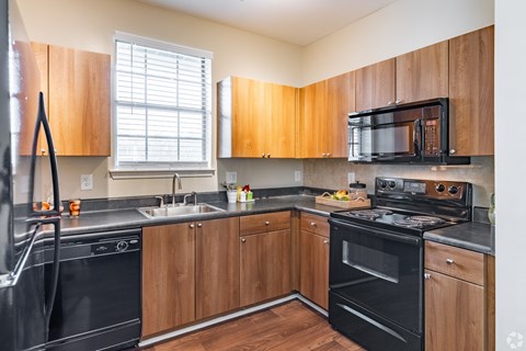 a kitchen with black appliances and wooden cabinets