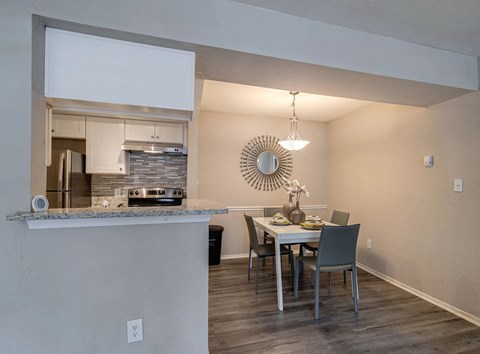 A modern kitchen with a dining table set for four.