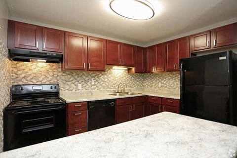 a kitchen with black appliances and granite counter tops