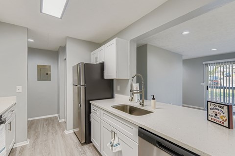 A modern kitchen with a black refrigerator and white countertops.