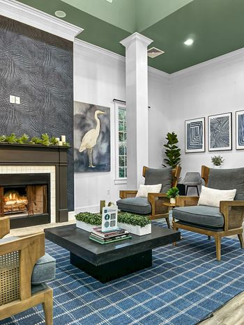 A living room with a fireplace and a blue rug.