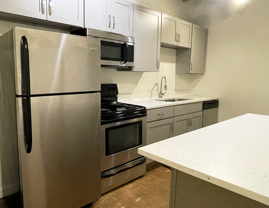a kitchen with white cabinets and stainless steel appliances