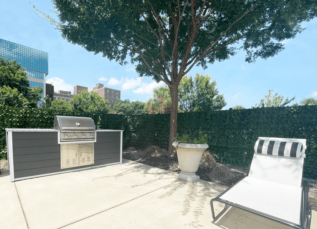 a backyard with a grill and lounge chair