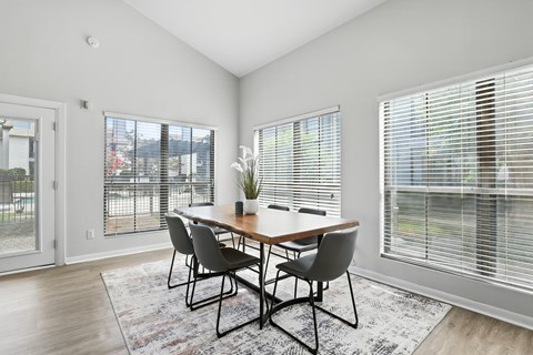 A dining room with a table and chairs.