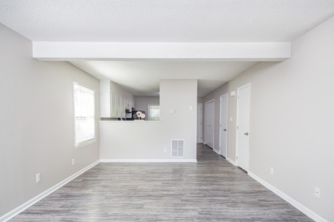 an empty living room with white walls and a wood floor