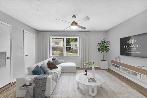 a living room with a white couch and a ceiling fan