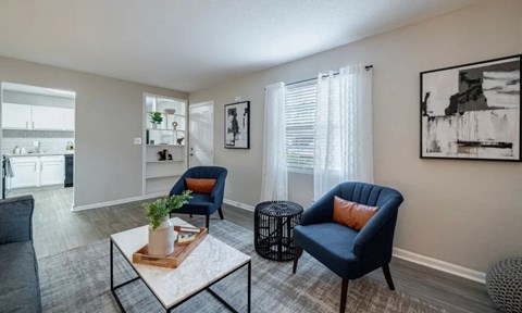 A living room with a blue chair and a coffee table.