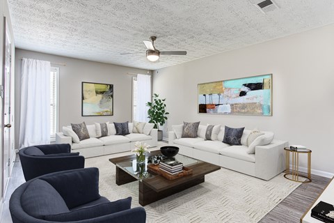 a living room with white couches and chairs and a coffee table