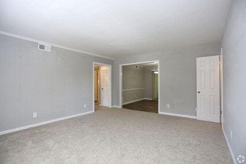 an empty living room with a white carpet and a white door
