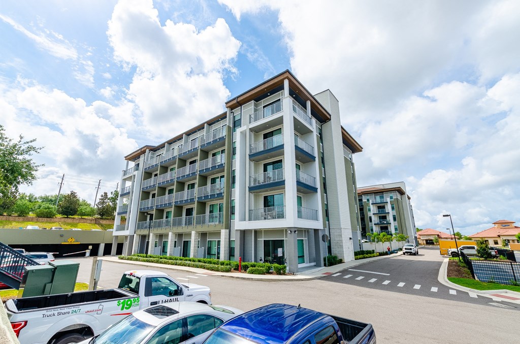 a large apartment building with cars parked in front of it at Lofts at South Lake, Florida, 34711