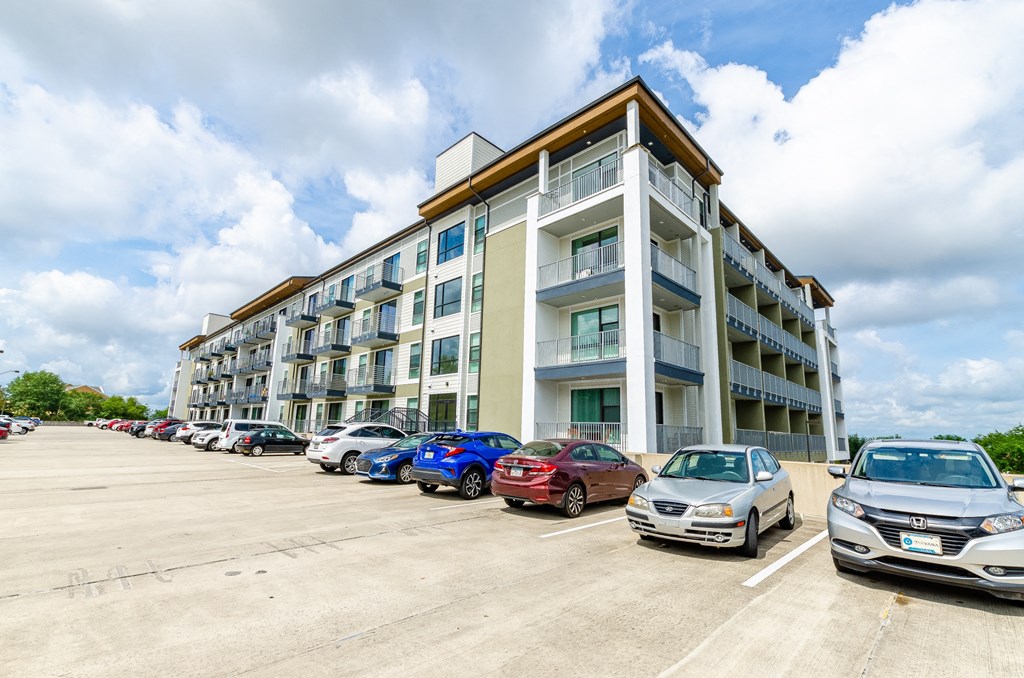 a parking lot with cars in front of an apartment building at Lofts at South Lake, Florida