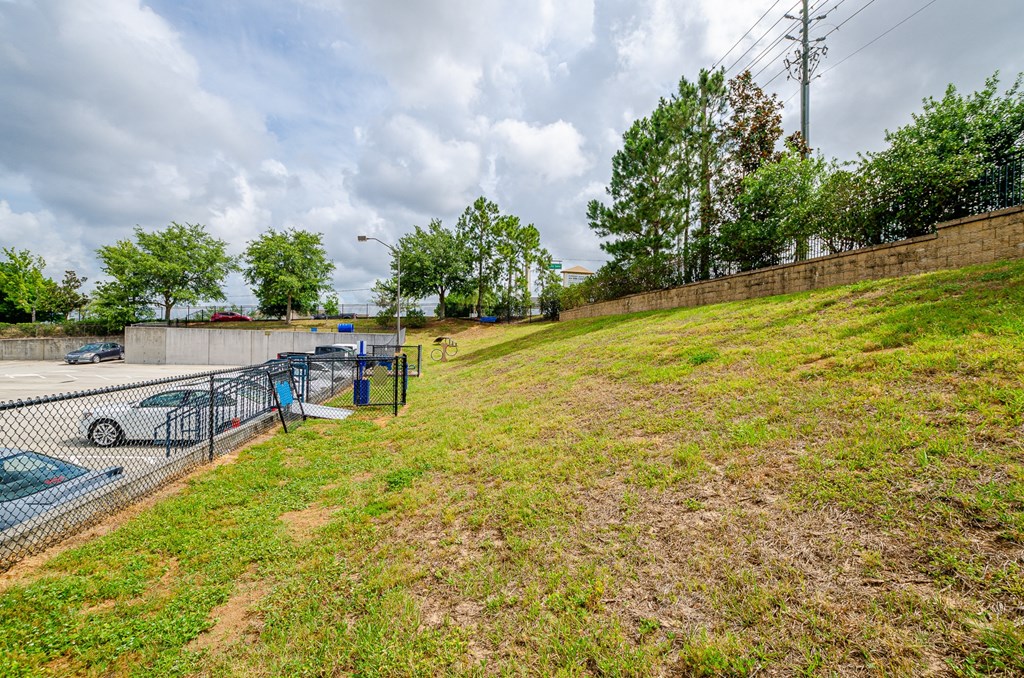 the yard of a parking lot with a fence and grass at Lofts at South Lake, Clermont, FL, 34711