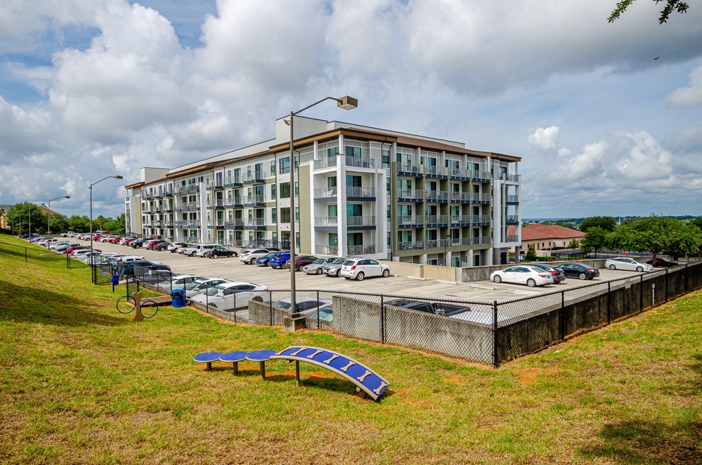 a large apartment building with a parking lot with cars at Lofts at South Lake, Clermont, 34711