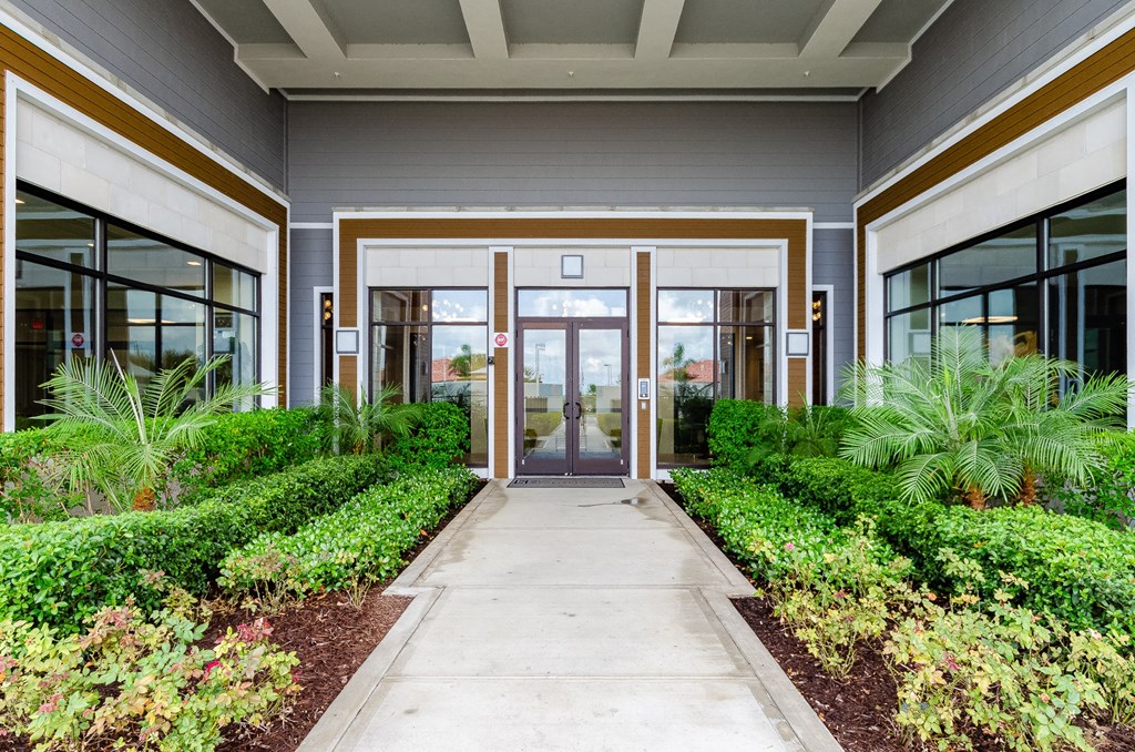 the entrance to a building with glass doors and a sidewalk at Lofts at South Lake, Clermont, FL, 34711
