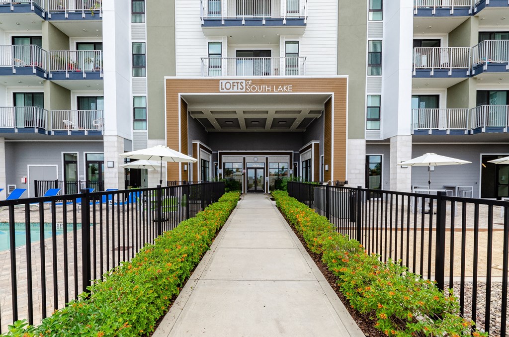 condominiums with a walkway and a fence in front of a pool at Lofts at South Lake, Florida, 34711