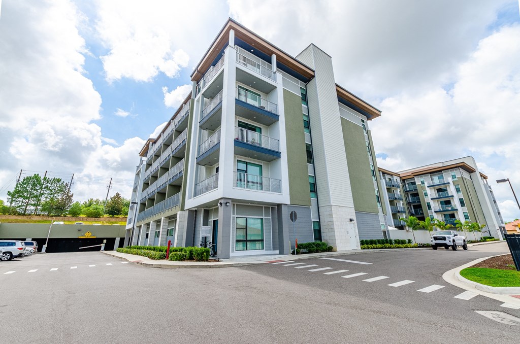 an apartment building with an empty parking lot and a cloudy sky at Lofts at South Lake, Clermont, 34711