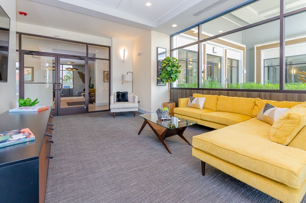 a living room with a yellow couch and a table at Lofts at South Lake, Florida, 34711