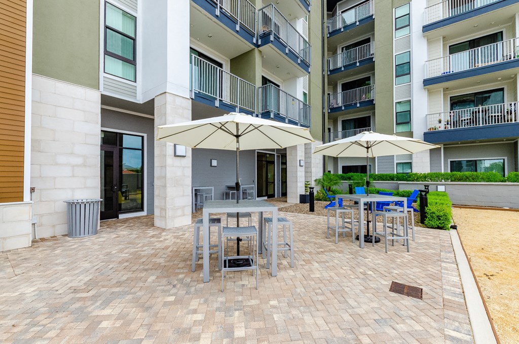 an outdoor patio with tables and umbrellas in an apartment building at Lofts at South Lake, Florida
