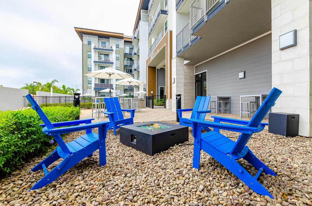 our patio has two blue chairs and a firepit with two blue tables and a at Lofts at South Lake, Clermont, FL, 34711