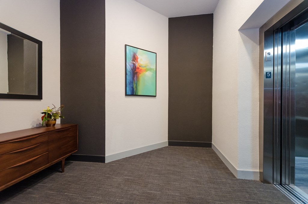 a hallway with a painting on the wall and a door to a elevator at Lofts at South Lake, Florida, 34711
