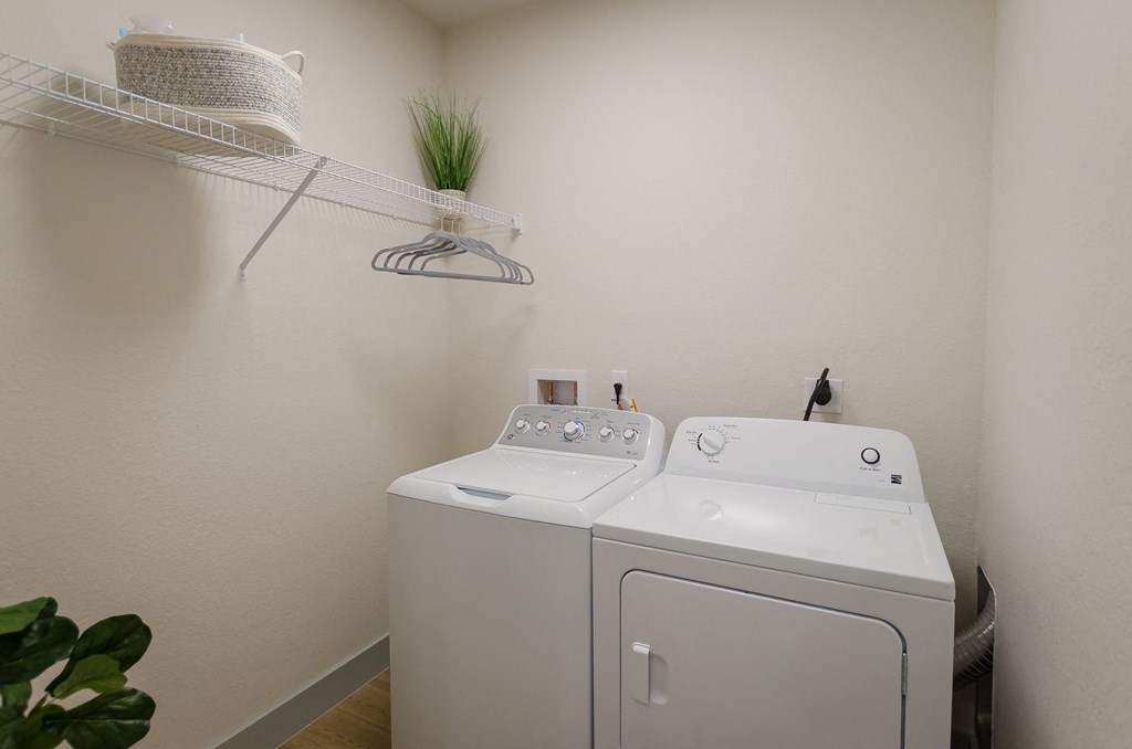 a washer and dryer in a laundry room with a shelf above it at Lofts at South Lake, Clermont, FL, 34711