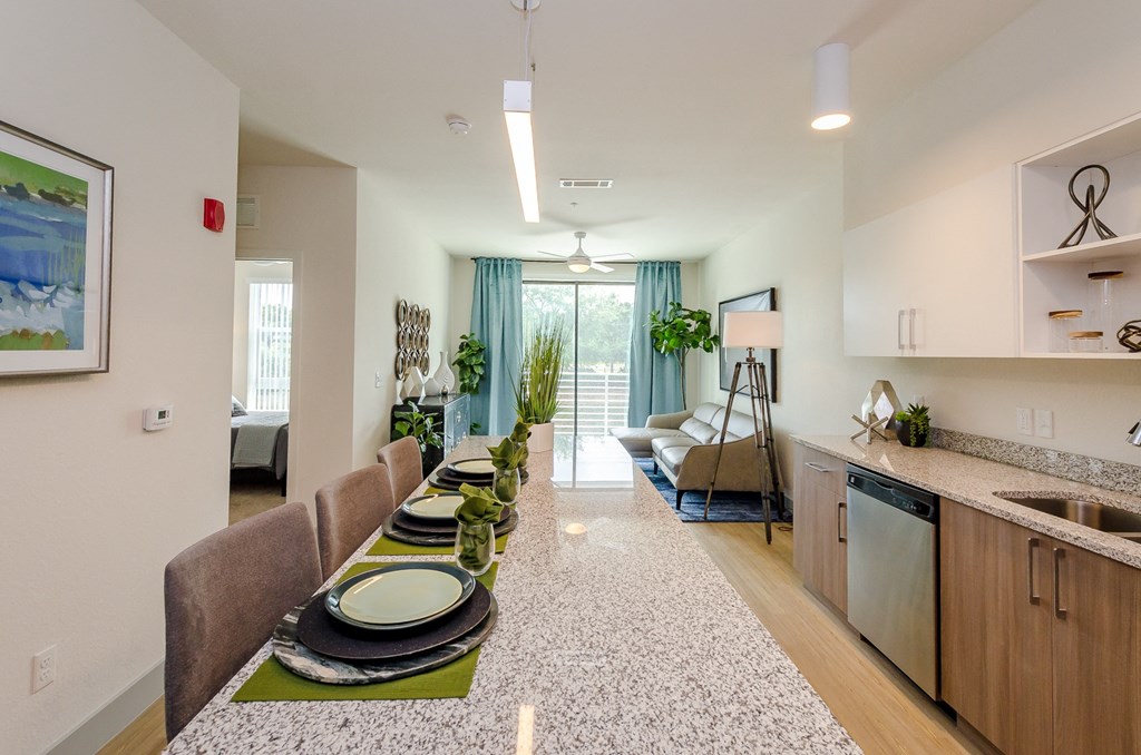 a living room with a dining room table and a kitchen at Lofts at South Lake, Florida, 34711