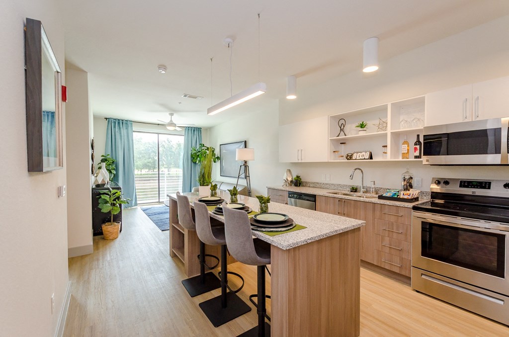 a kitchen and dining room area with a table and chairs and a large window at Lofts at South Lake, Clermont, FL, 34711