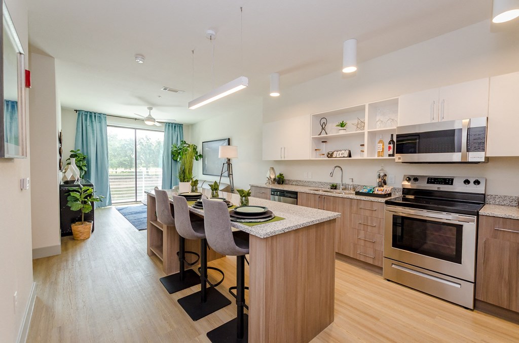 a kitchen and dining area with wooden floors and stainless steel appliances at Lofts at South Lake, Florida