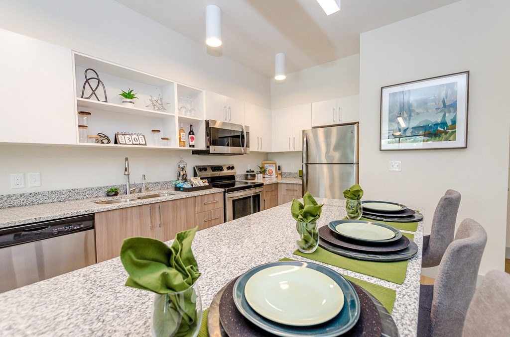 a dining room with a table and chairs and a kitchen at Lofts at South Lake, Clermont, FL, 34711