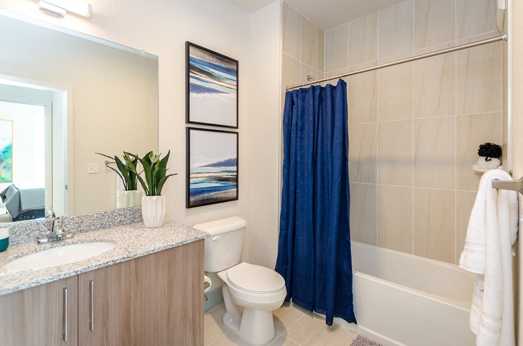 a bathroom with a blue shower curtain and a white toilet at Lofts at South Lake, Florida, 34711